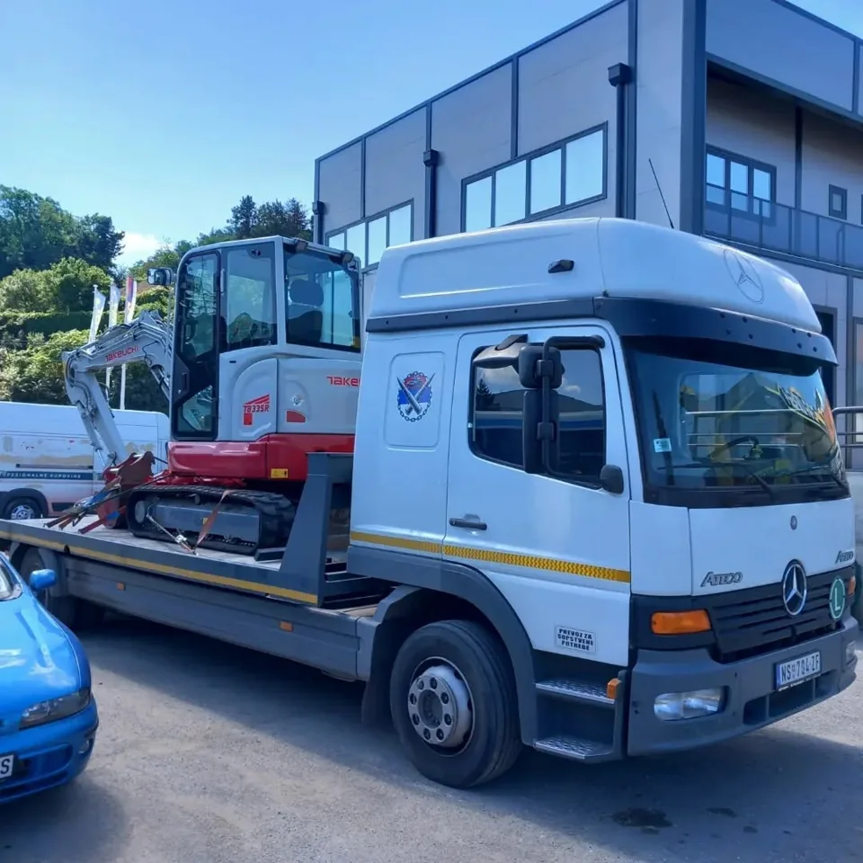 Mini-bager Takeuchi na platformi kamiona Mercedes-Benz Atego.